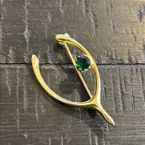 Elegant Gold Wishbone Brooch with Green Gemstone Luck